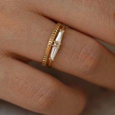 a close up of a person's hand wearing two rings