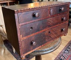 an old wooden dresser sitting on top of a stool