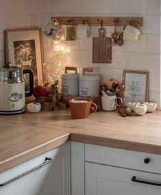 the kitchen counter is cluttered with items for cooking and decor on it, including coffee mugs