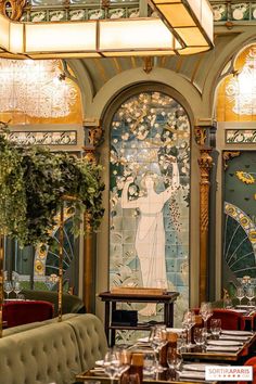 an ornately decorated dining room with tables and chairs in front of a stained glass window