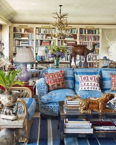 a living room filled with lots of furniture and bookshelves covered in bookcases