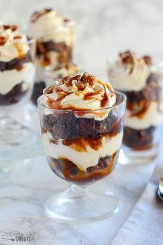 three desserts in small glass jars on a table