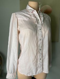 80s Retro Western Women's Button Up Ruffle Pink Long Sleeve Medium Description: Light pink Western button up, with Ruffle details, puff sleeves, and pearlized buttons.  Details: Some minor snags Great condition  Measurements:  No size on tag, estimated: Medium  Pit to Pit: 20 inches  Waist: 17.5 inches Hem Width: 20.5 inches Sleeve Length: 23 inches Shoulder to Hem Length: 25 inches Fitted Collared Tops With Pearl Buttons, Classic Tops With Pearl Buttons For Spring, Spring Button-up Blouse With Pearl Buttons, Feminine Tops With Pearl Buttons, Feminine Spring Blouse With Pearl Buttons, Feminine Fitted Tops With Pearl Buttons, Spring Feminine Blouse With Pearl Buttons, Vintage Pink Tops With Button Closure, Vintage Pink Tops With Buttons