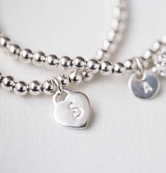 These stunning initial heart bracelets are made with Sterling silver and beaded with 3mm Sterling silver beads on stretch cord. You can add up to 5 Heart charms each with initial of your choice. This hand stamped Heart bracelet is the prefect layering bracelet or keep it simple and wear it alone. Bracelet measuring about 61/2 -7inches. Please contact for custom sizing.*Price is for one sterling silver bracelet * All Jewelry is personalized and packaged in our small studio * Order are shipped out Bridesmaid Gift Bracelet, Initial Bracelet Silver, Bridesmaid Bracelet Gift, Heart Bracelets, Goddaughter Gifts, Silver Heart Bracelet, Bracelet Initial, Gift Bracelet, Custom Bracelet