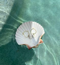 Dive into the elegance of the ocean with our Marina Shell Hoop Earrings. These stunning hoops, featuring natural shell accents, bring a touch of seaside charm to any outfit.  Each pair of Marina Shell Hoop Earrings is adorned with authentic, ethically-sourced shells from the coast of Englewood Beach. Hoop Earrings For Beach With Pierced Ears, Small Hoop Earrings For Summer Beach, White Small Hoop Jewelry For The Beach, Small Hoop Earrings For Vacation, White Small Hoop Earrings For Beach, White Hoop Earrings For Vacation, White Beaded Hoop Earrings For Beach, Summer Beach Hoop Earrings, Handmade Shell Hoop Earrings For Summer