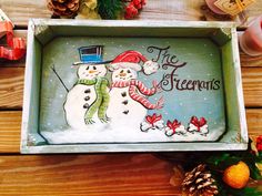 a wooden tray decorated with two snowmen and the words, the christmas season is here