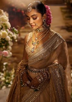 a woman in a brown sari and jewelry