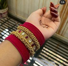 a woman's hand with henna and bracelets on it