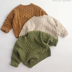 three sweaters are laid out on a white surface, one is green and the other is brown