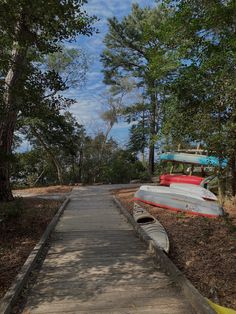 a boat sitting on top of a wooden dock in the woods next to some trees