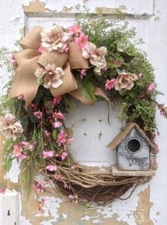 a wreath with flowers and a bird house