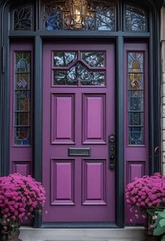 a purple front door with two pink flowers