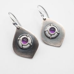 Sterling silver dangle earrings featuring a genuine 5mm Amethyst stone with a drop length of 40mm (1.57"). Perfect for everyday wear with any outfit, combining boho and chic styles. All of our pieces are made to order, so please allow for roughly 1-3 days for us to create your unique item. While we strive to make our products match the photos as closely as possible, please keep in mind that there may be slight variations. If you want to see more of our handmade earrings, please visit our Etsy sh Modern Purple Gemstone Earrings, Handmade Purple Sterling Silver Earrings, Sterling Silver Teardrop Oxidized Earrings, Modern Sterling Silver Pendant Earrings, Purple Teardrop Metal Earrings, Modern Amethyst Gemstone Earrings, Nickel-free Amethyst Dangle Earrings, Nickel Free Amethyst Dangle Earrings, Modern Amethyst Earrings As Gift