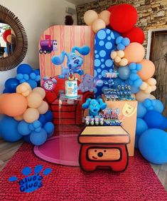 a birthday party with balloons and decorations on the floor, including an elephant cake table