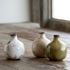 three vases sitting on top of a wooden table