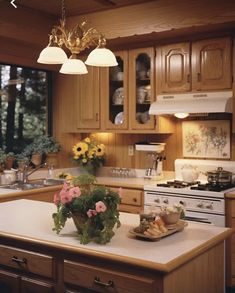 a kitchen with wooden cabinets and an island in front of the stove, sink and oven