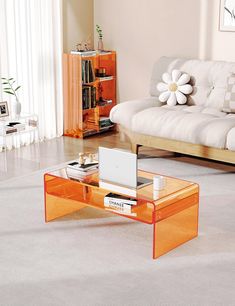 a living room with a couch, coffee table and bookshelf on the floor