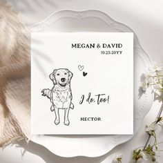 a white plate with a drawing of a dog on it next to flowers and a napkin