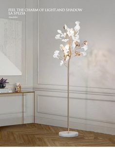 a floor lamp with white flowers on it in a living room next to a table