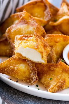 some fried food on a white plate with dipping sauce