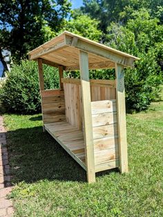 a small wooden outhouse sitting in the grass