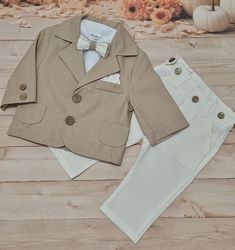 Einklassischer Jungenanzug aus Leinen ist ein elegantes Set für one Anlass. Das Set beinhaltet: 1. Beige Leinenjacke with Baumwollfutter. 2. Cremefarbene Leinenhose mit schmalem Schnitt. Knopflaschen vorne an der Taille zum Anpassen des Umfangs. 3. Weißes Body-Shirt mit kurzen Ärmeln. 4. Eine Fliege, um es elegant zu machen :) Komposition: Jacke, Hose: 85% Leinen, 15% Viskose Hemd: 100% Baumwolle Waschempfehlungen: Handwäsche bei 30 Grad. Rücksendungen innerhalb von 14 Tagen auf Kosten des Käufe Baby Boy Suit, Boy Baptism Outfit, Baptism Outfit, Boys Suits, Formal Suits, Baby Boys, Baby Boy Outfits, Christening, Boy's Clothing