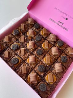 a pink box filled with lots of brownies