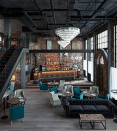 the interior of a restaurant with couches, tables and stairs leading up to an open floor plan