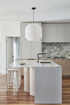 a kitchen with marble counter tops and stools next to an island in the middle