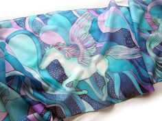 Hand painted scarf with Pegasus made of natural silk, in purple - blue - turquoise color set. This fantasy designer scarf is made to order. The Pegasus is a magical creature, a winged horse symbolizing wisdom and fame and more recently poets' inspiration (so imagine what a lovely gift the scarf would made for your poet friend). The Pegasus scarf depicts the winged horse flying with two peacocks on a starry, cloudy night sky. It is composed with tones of cool blue and turquoise, soft pastel mint Blue Hand Painted Bohemian Silk Scarf, Blue Bohemian Hand Painted Silk Scarf, Hand Painted Blue Silk Scarf For Gift, Bohemian Blue Hand Painted Silk Scarf, Artistic Handmade Blue Silk Scarf, Bohemian Blue Silk Scarf Gift, Bohemian Blue Silk Scarf As Gift, Bohemian Blue Silk Scarf For Gift, Artsy Blue Scarf As A Gift