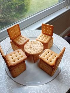 a plate topped with cookies and crackers next to a cup of coffee