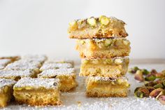 a stack of four pieces of cake sitting on top of a table next to nuts