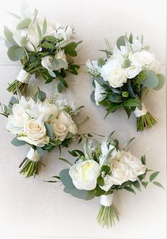 white flowers and greenery are arranged on the floor