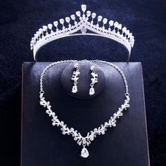 A delicate three-piece bridal jewelry set for the romantic bride! Adorned with intricately faceted cubic zirconia that capture the light from every angle with a perfectly translucent appeal, the pieces are rhodium plated for a flawless finish which enhances the intricate detailing and conveys a modern take on old elegance. Necklace: 17" long (approx. 43.2cm) with a 2" extension chain (approx. 5cm) for comfortable sizing (if you would like it longer, please include a note with the preferred lengt Silver Bridal Sets With Diamond Accents, Elegant White Bridal Set, Silver Cubic Zirconia Bridal Accessories, Cubic Zirconia Bridal Set With Sparkling Stones For Wedding, Dazzling Cubic Zirconia Bridal Sets For Wedding, Wedding Jewelry Sets With Rhinestones And Cubic Zirconia, Wedding Jewelry Sets With Rhinestones In Cubic Zirconia, Elegant Crystal Bridal Sets With Rhinestones, Elegant Bridal Sets With Rhinestones And Crystal