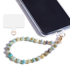 a cell phone is next to a beaded bracelet