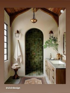 a bathroom with a green tile shower and white counter tops, along with a rug on the floor