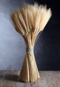 a bunch of dried wheat sitting on top of a wooden table