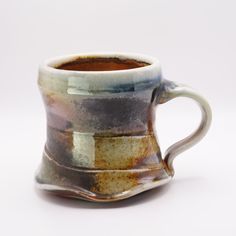 a brown and white coffee cup sitting on top of a table