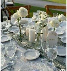 the table is set with white flowers and candles