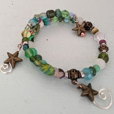 This Is A Fun Bracelet With Various Glass Beads In Shades Of Blue And Green With Handmade Coil Spirals Hanging From The Ends. Unique Bead Bracelets, Blue Bracelets Aesthetic, Grudge Bracelets, Sea Glass Bracelets, Beaded Crystal Bracelets, Grunge Bracelet Ideas, Bracelet Ideas Grunge, Wire Bracelet Ideas, Goblincore Bracelet