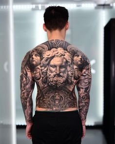 a man with many tattoos on his back