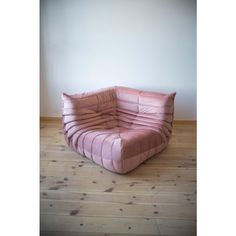 a pink chair sitting on top of a wooden floor