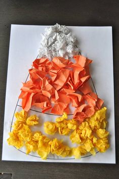 a paper plate with orange and yellow flowers on it next to a piece of white paper