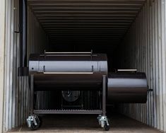 a large black bbq grill sitting inside of a storage container with wheels on the side