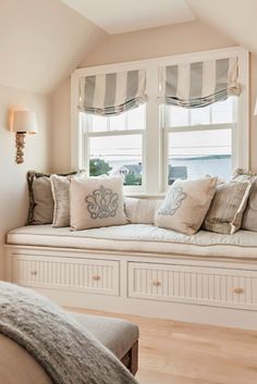 a window seat with pillows on it in a bedroom