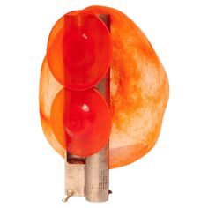 an orange lamp with two red lights on it's sides and a white background