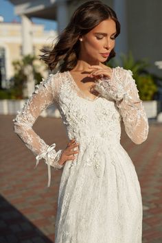 a woman in a white dress posing for the camera