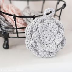 two crocheted balls sitting in a basket next to each other on a table