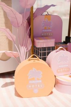 pink and yellow suitcases sitting on top of a white table next to each other