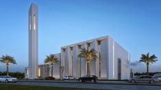 a large white building with palm trees in front of it and cars parked on the street